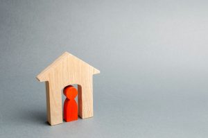 Miniature wooden house with a tenant inside